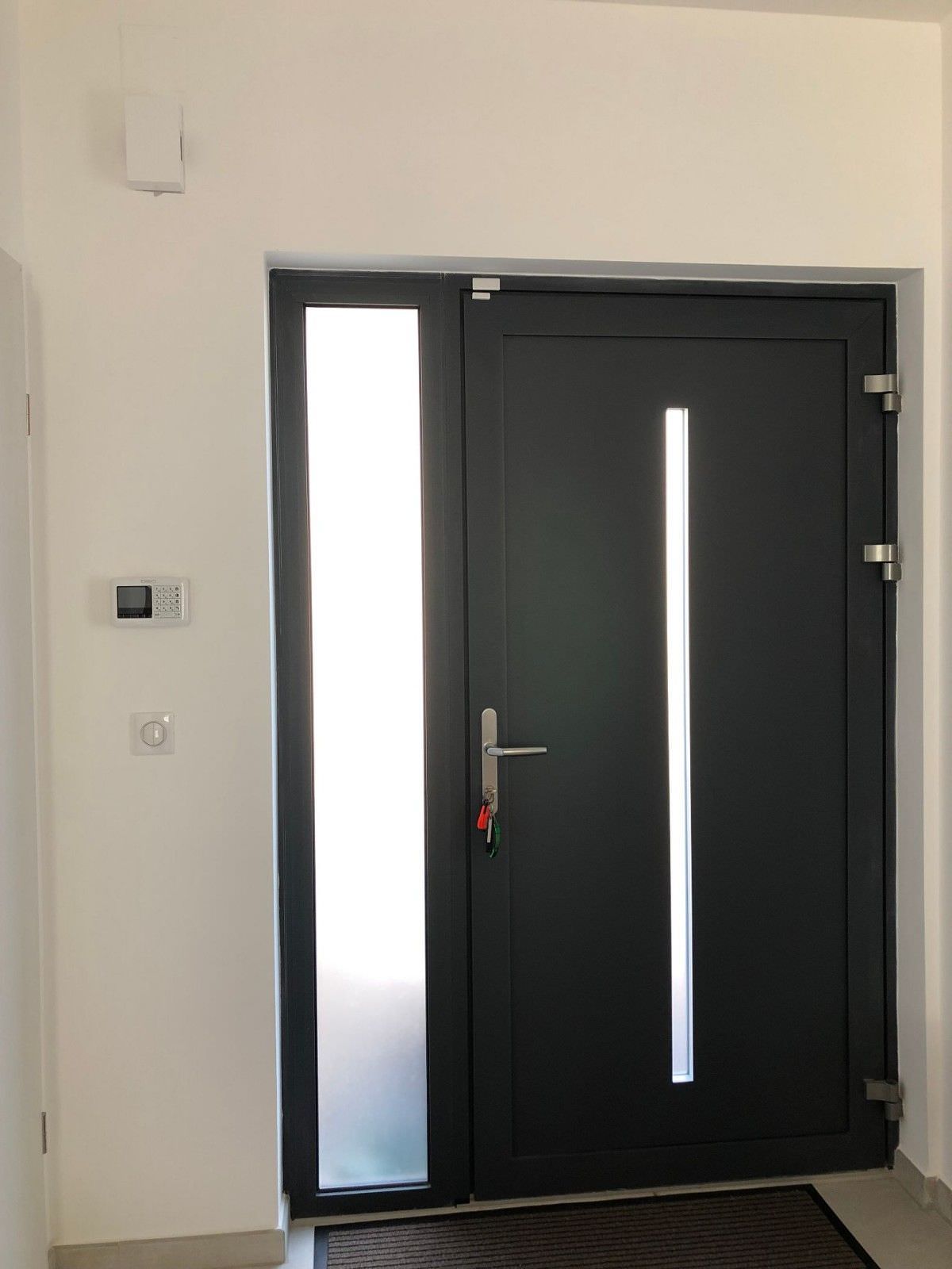 Installation d'une porte d'entrée alu moderne avec tierce vitrée